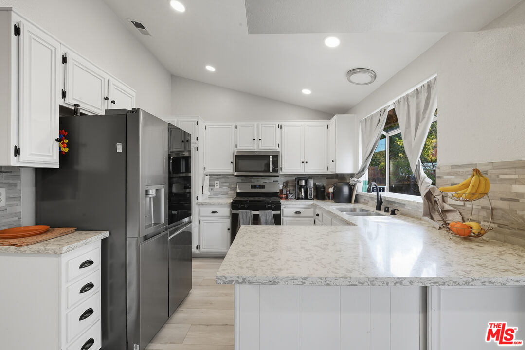 2048 East Ave R 10 Palmdale, CA 93550 - Photo 16 of 45 a kitchen with stainless steel appliances granite countertop a refrigerator and a sink