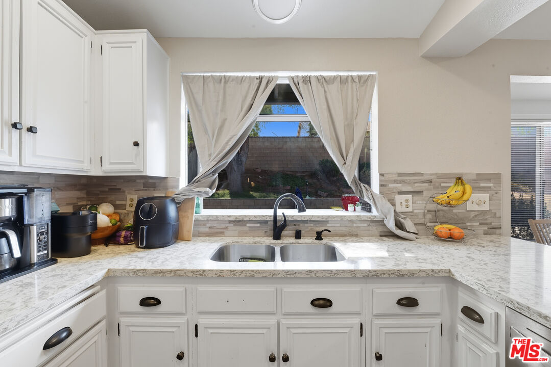 2048 East Ave R 10 Palmdale, CA 93550 - Photo 18 of 45 a kitchen with a sink a stove and cabinets