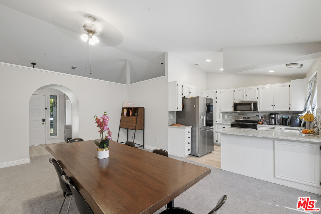 2048 East Ave R 10 Palmdale, CA 93550 - Photo 24 of 45 a living room with stainless steel appliances kitchen island a table and chairs