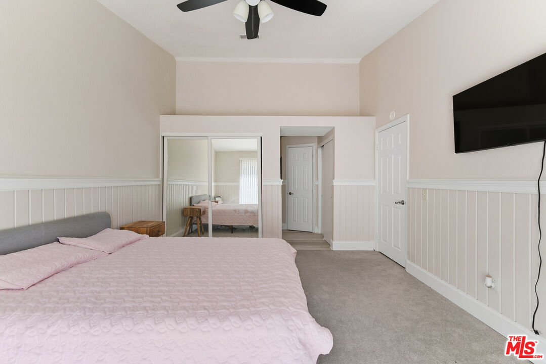 2048 East Ave R 10 Palmdale, CA 93550 - Photo 28 of 45 a bedroom with a bed and a flat screen tv