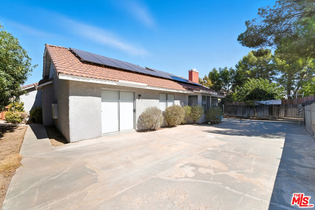 2048 East Ave R 10 Palmdale, CA 93550 - Photo 42 of 45 a front view of a house with a yard and garage