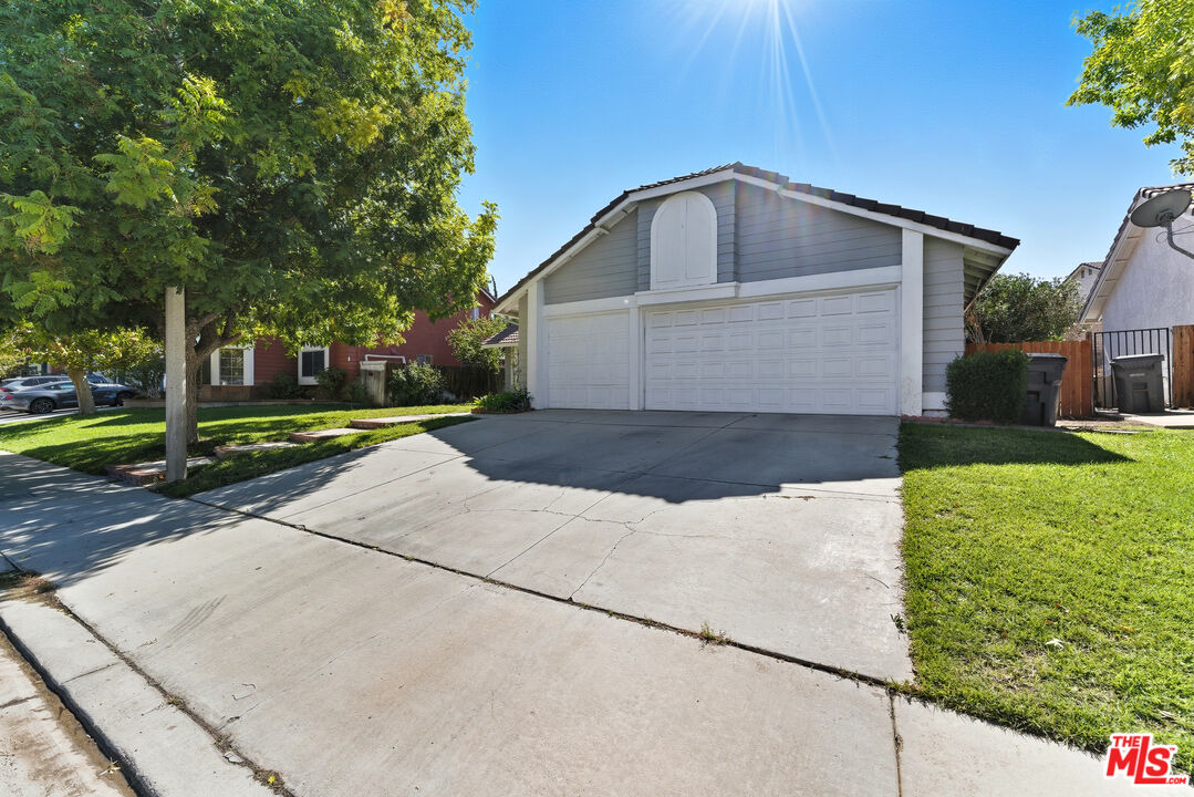 2048 East Ave R 10 Palmdale, CA 93550 - Photo 7 of 45 a front view of a house with a yard and garage