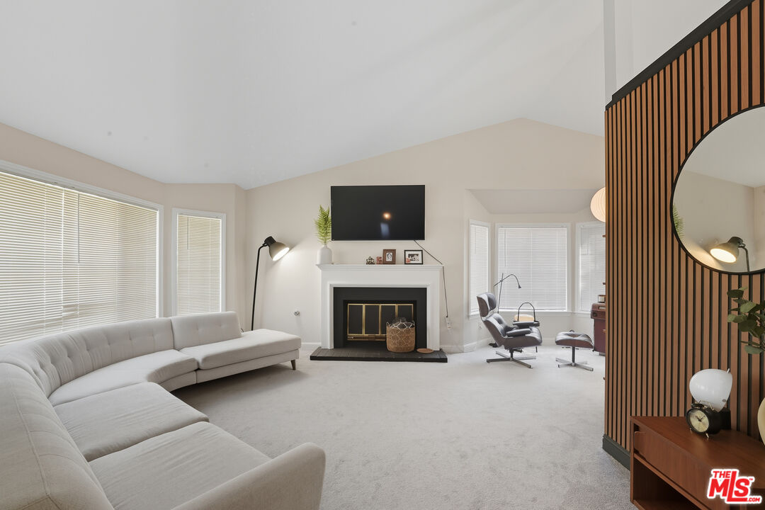 2048 East Ave R 10 Palmdale, CA 93550 - Photo 8 of 45 a living room with furniture a fireplace and a flat screen tv