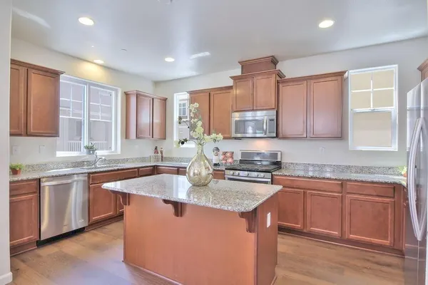 a kitchen with stainless steel appliances granite countertop a sink stove and cabinets