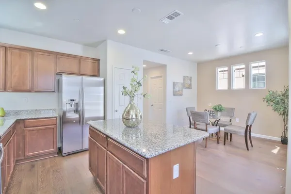 a kitchen with granite countertop kitchen island stainless steel appliances a table and chairs