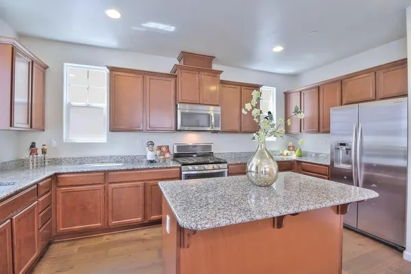 a kitchen with stainless steel appliances granite countertop a sink stove and refrigerator