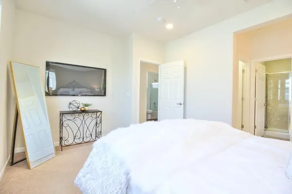 a spacious bedroom with a bed and a flat screen tv