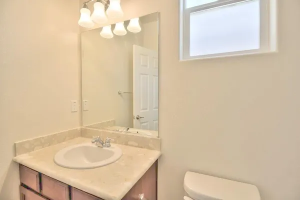 a bathroom with a sink vanity mirror and toilet