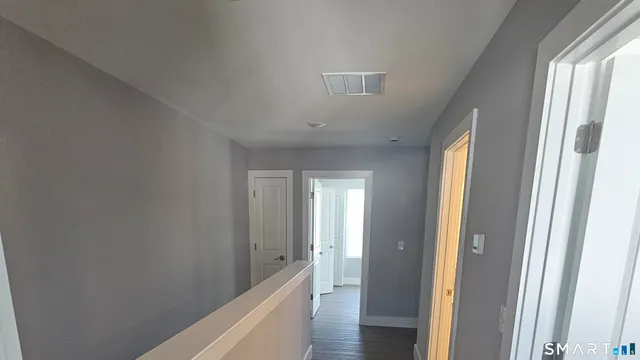 a view of hallway with windows and wooden floor