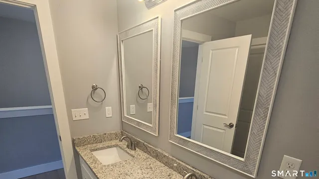 a bathroom with a granite countertop sink and a mirror