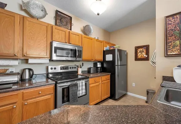 a kitchen with stainless steel appliances granite countertop a stove top oven a sink dishwasher and cabinets with wooden floor