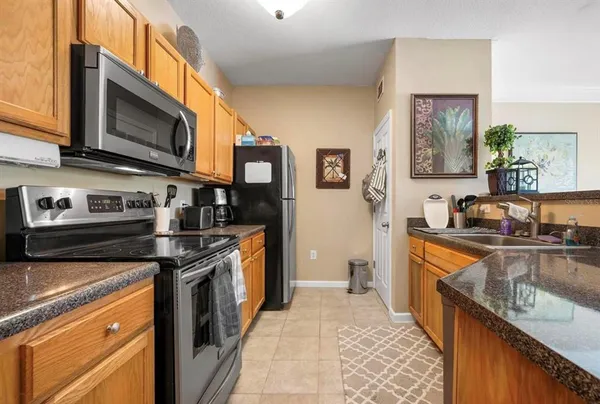 a kitchen with stainless steel appliances granite countertop a stove a sink and a microwave