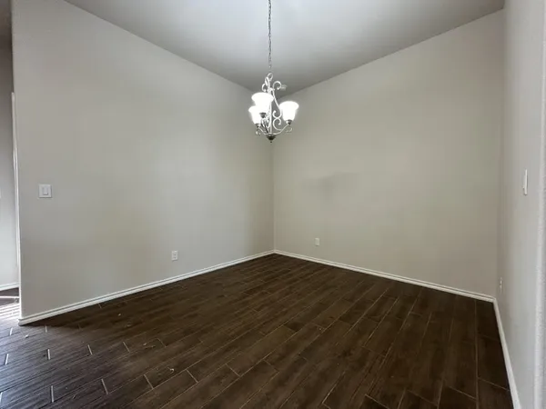 a view of a room with wooden floor and a ceiling fan