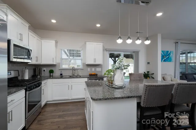 a kitchen with granite countertop kitchen island cabinets and appliances