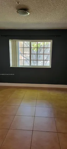 a view of a room with an empty space and a window