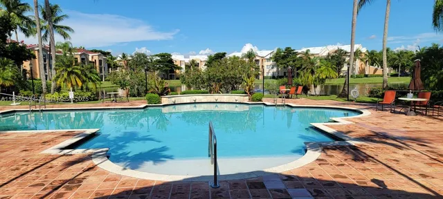a view of a swimming pool with a patio and a yard