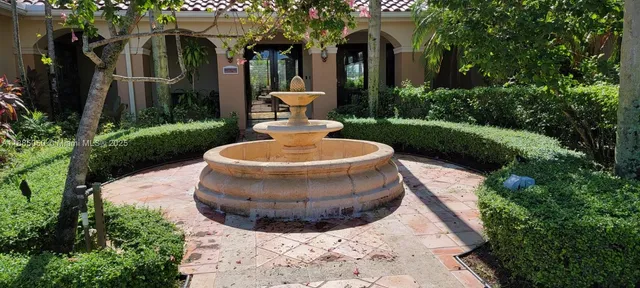 a view of a white house with a yard and potted plants