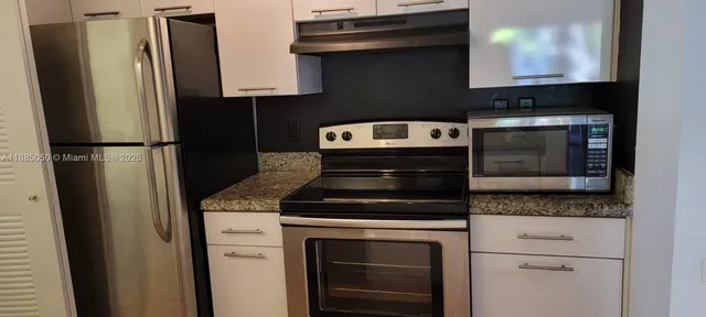 a kitchen with stainless steel appliances granite countertop a refrigerator stove and sink