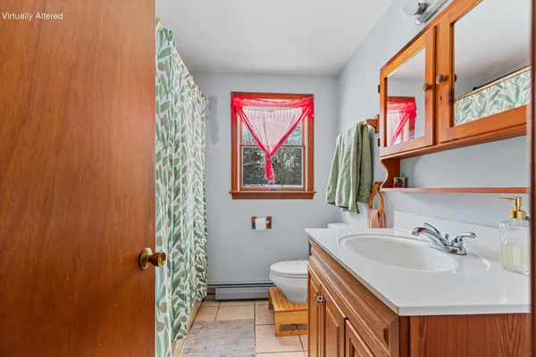 a bathroom with a sink a toilet and shower curtain