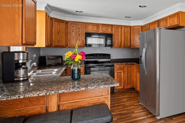 a kitchen with stainless steel appliances granite countertop a refrigerator sink and stove