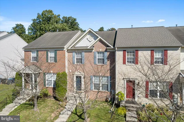 a front view of a house with a yard and potted plants