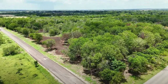 a view of a green yard with an outdoor seating