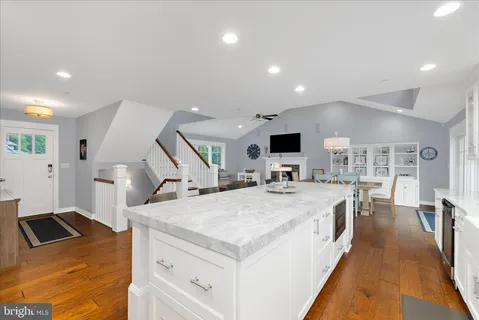 a living room with furniture and a dining table with wooden floor