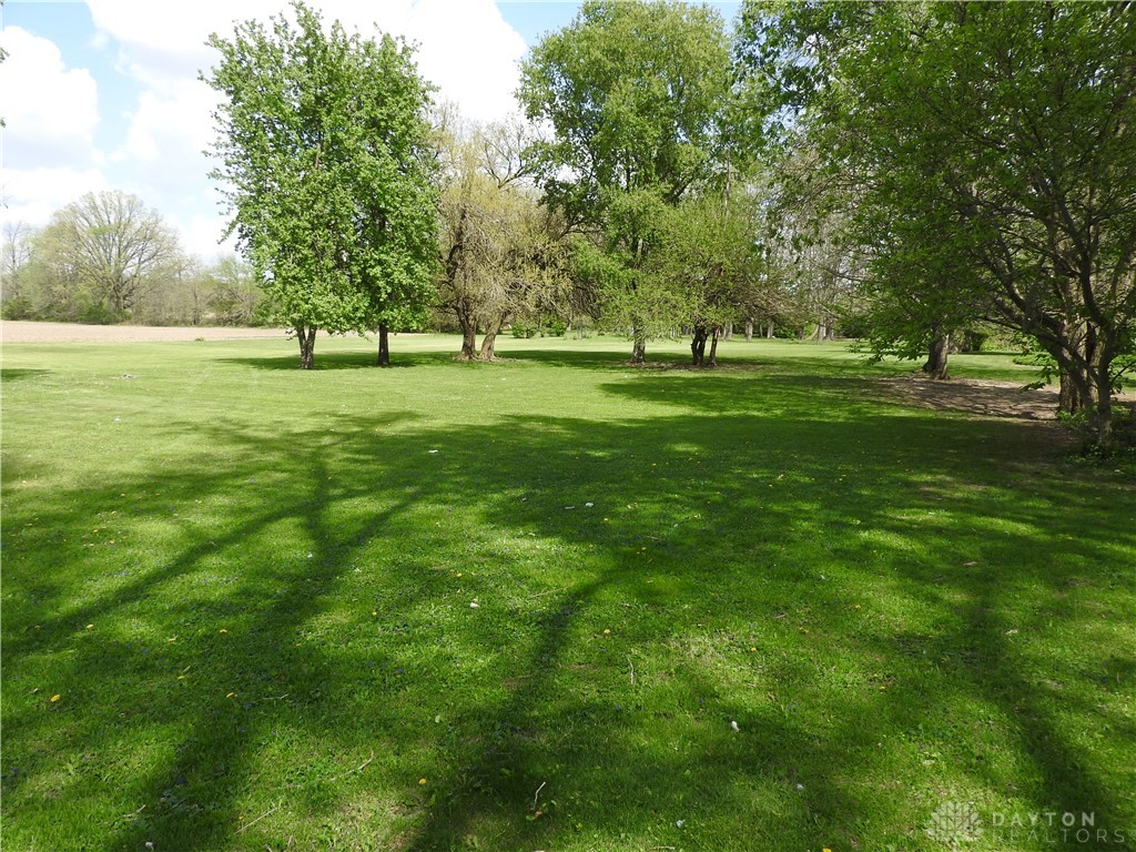 2105 East Loy Road Piqua, OH 45356 - Photo 9 of 26 Expansive green yard with mature trees offers abundant outdoor space and shade.
