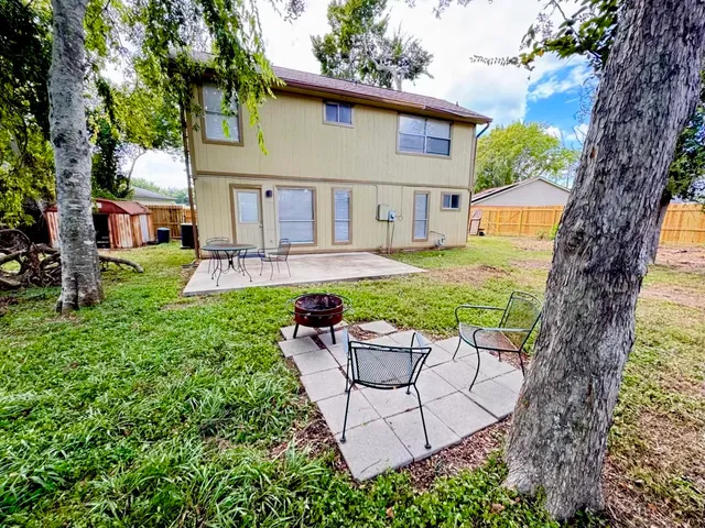 a view of a house with backyard and sitting area
