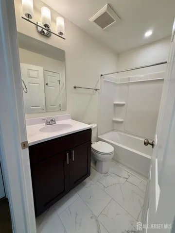 a bathroom with a sink vanity mirror and toilet