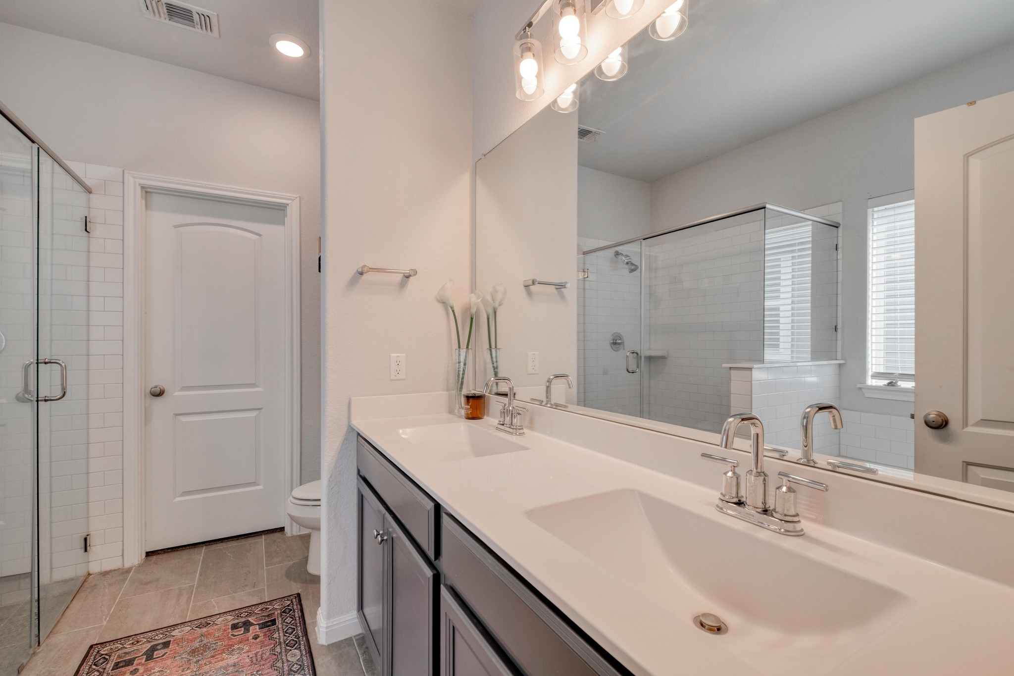 19425 Forman Drive Pflugerville, TX 78660 - Photo 13 of 25 Bathroom featuring double vanity, light tile patterned floors, a stall shower, and recessed lighting