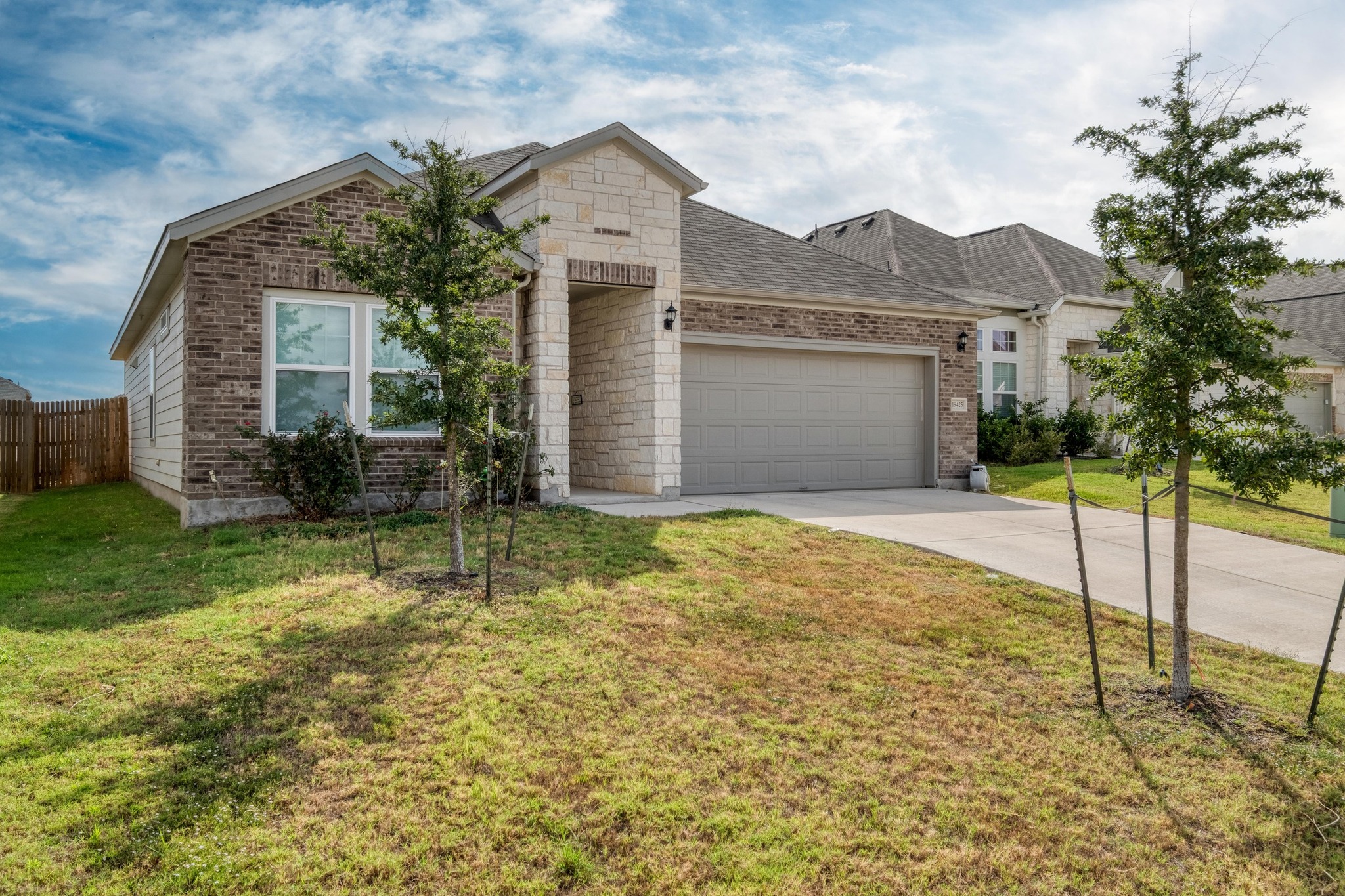 19425 Forman Drive Pflugerville, TX 78660 - Photo 23 of 25 View of front of house with brick siding, concrete driveway, an attached garage, and a front yard