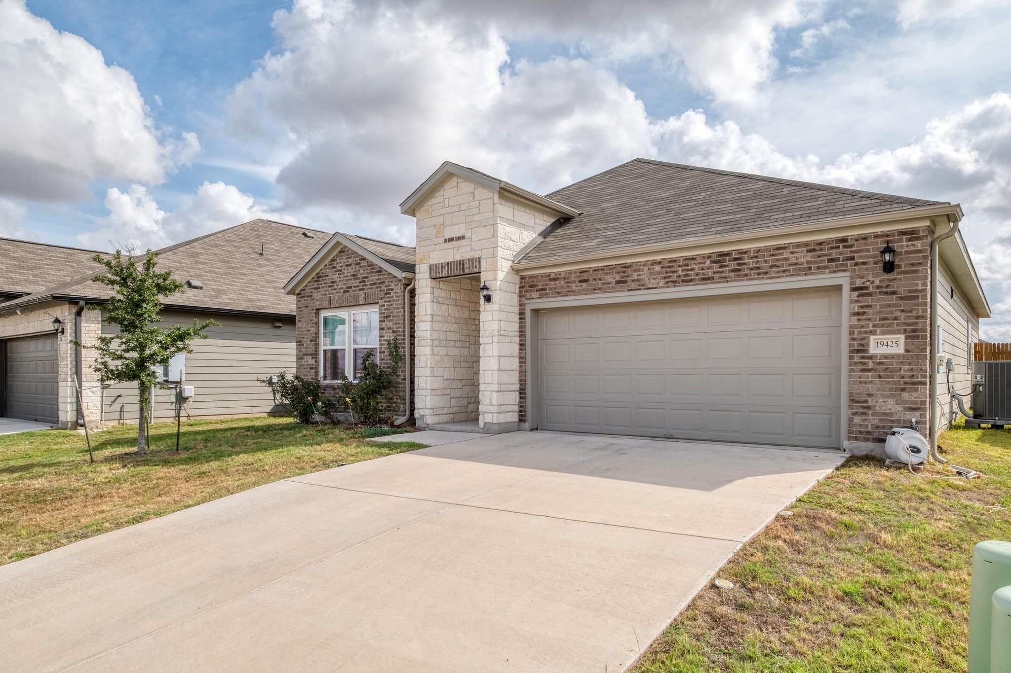19425 Forman Drive Pflugerville, TX 78660 - Photo 24 of 25 View of front of home with brick siding, a garage, roof with shingles, and concrete driveway