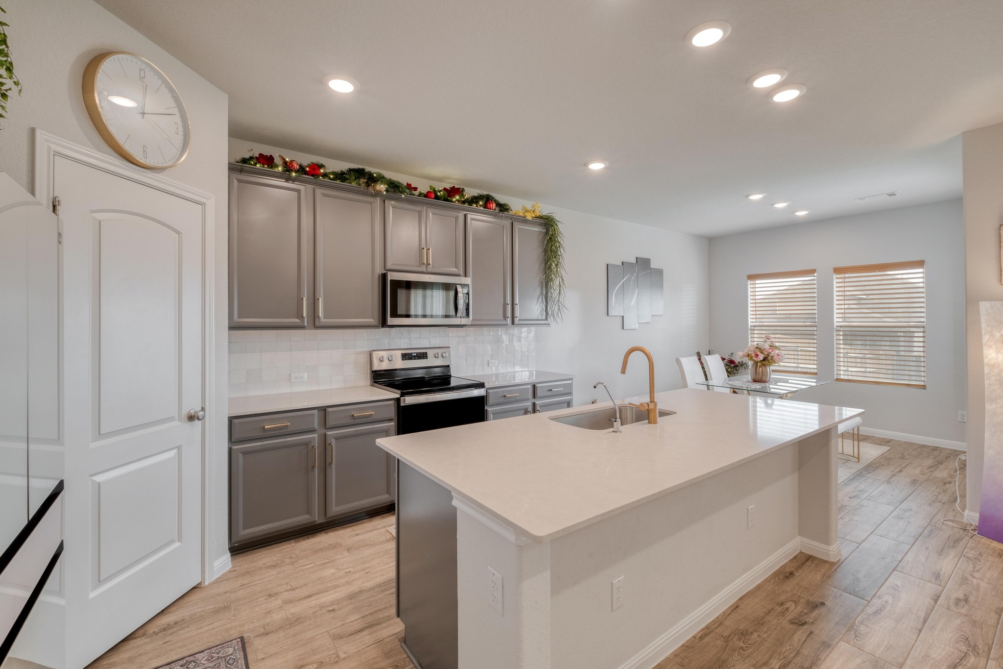 19425 Forman Drive Pflugerville, TX 78660 - Photo 7 of 25 Kitchen with decorative backsplash, recessed lighting, an island with sink, light wood-style floors, and stainless steel appliances
