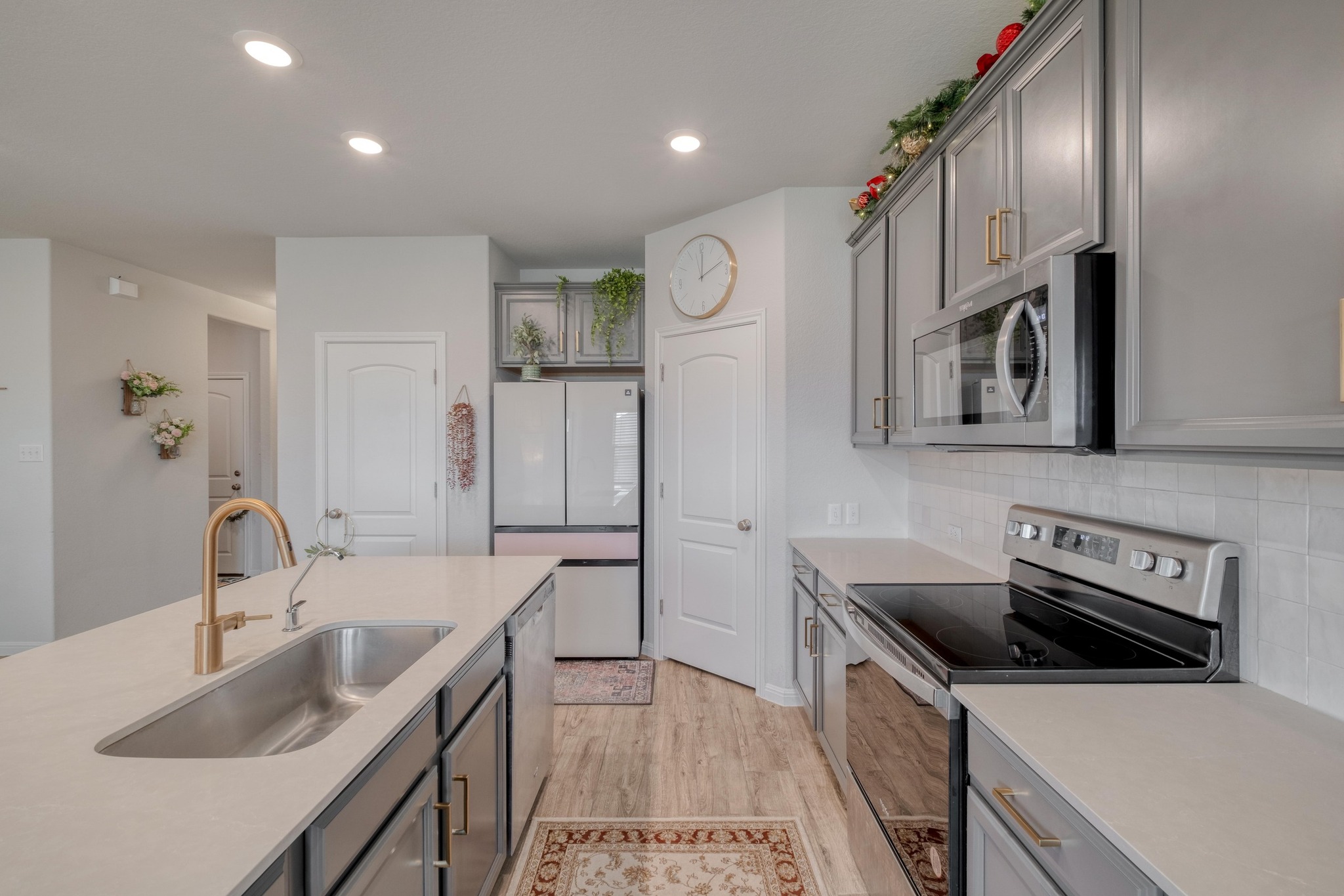 19425 Forman Drive Pflugerville, TX 78660 - Photo 8 of 25 Kitchen with stainless steel appliances, light wood-style floors, gray cabinetry, recessed lighting, and backsplash