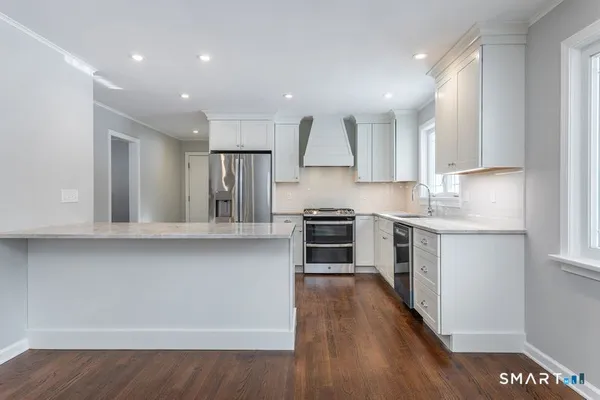 a kitchen with stainless steel appliances a refrigerator and a stove top oven