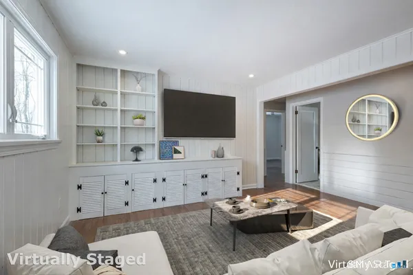 a living room with furniture a flat screen tv and a window