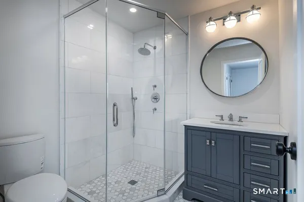 a bathroom with a toilet a sink and mirror