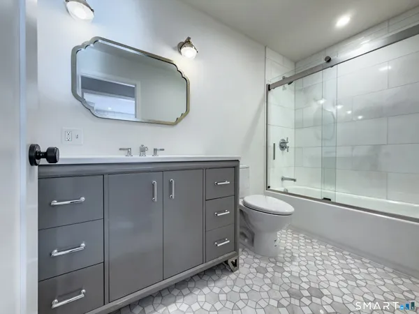 a bathroom with a toilet a sink and mirror