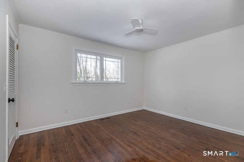 102 Wykeham Road Washington, CT 06793 - Photo 2 of 24 a view of an empty room with wooden floor and a window