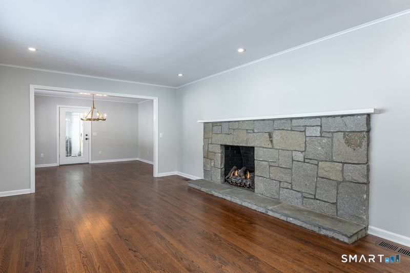 102 Wykeham Road Washington, CT 06793 - Photo 5 of 21 an empty room with wooden floor fireplace and windows