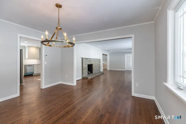 a view of a room with wooden floor fireplace and windows
