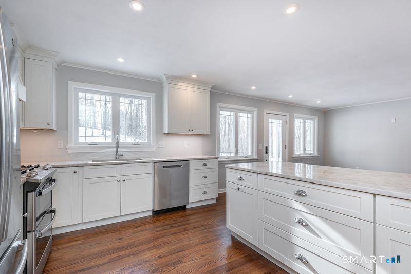 102 Wykeham Road Washington, CT 06793 - Photo 9 of 21 a large white kitchen with granite countertop white cabinets and white appliances