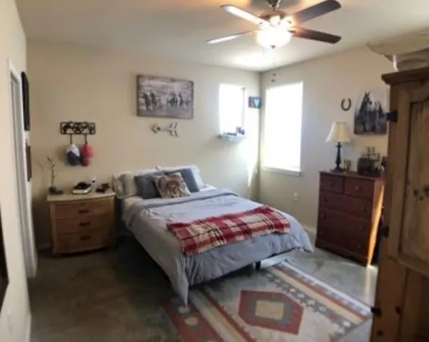 a bathroom with a granite countertop sink a toilet a mirror and shower curtain