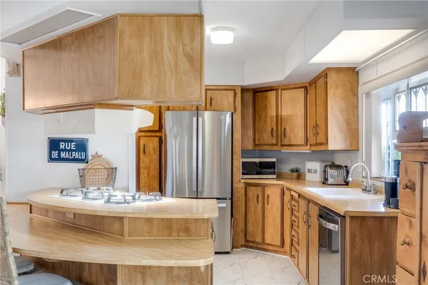 a kitchen with a sink a counter top space and a refrigerator