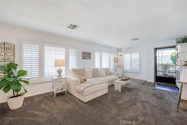 a spacious bedroom with a bed a chandelier and a window