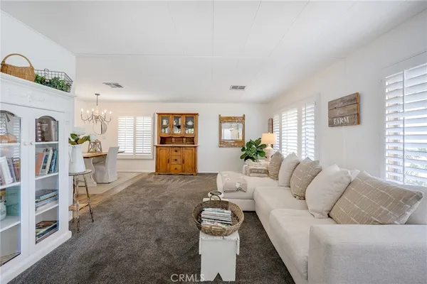 a living room with furniture chandelier and fireplace
