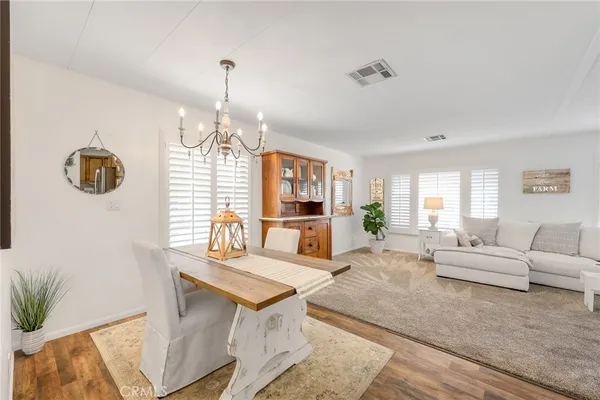 a dining room with wooden floor and chandelier
