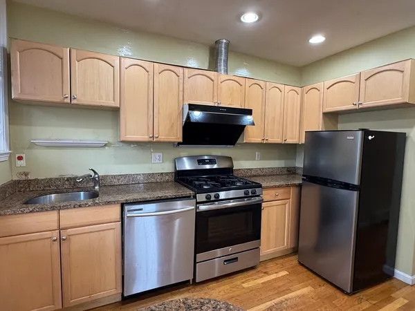 a kitchen with granite countertop a refrigerator stove and microwave