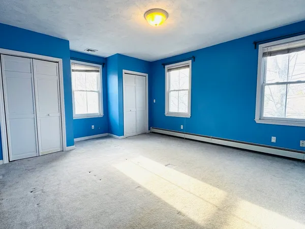 an empty room with windows and closet